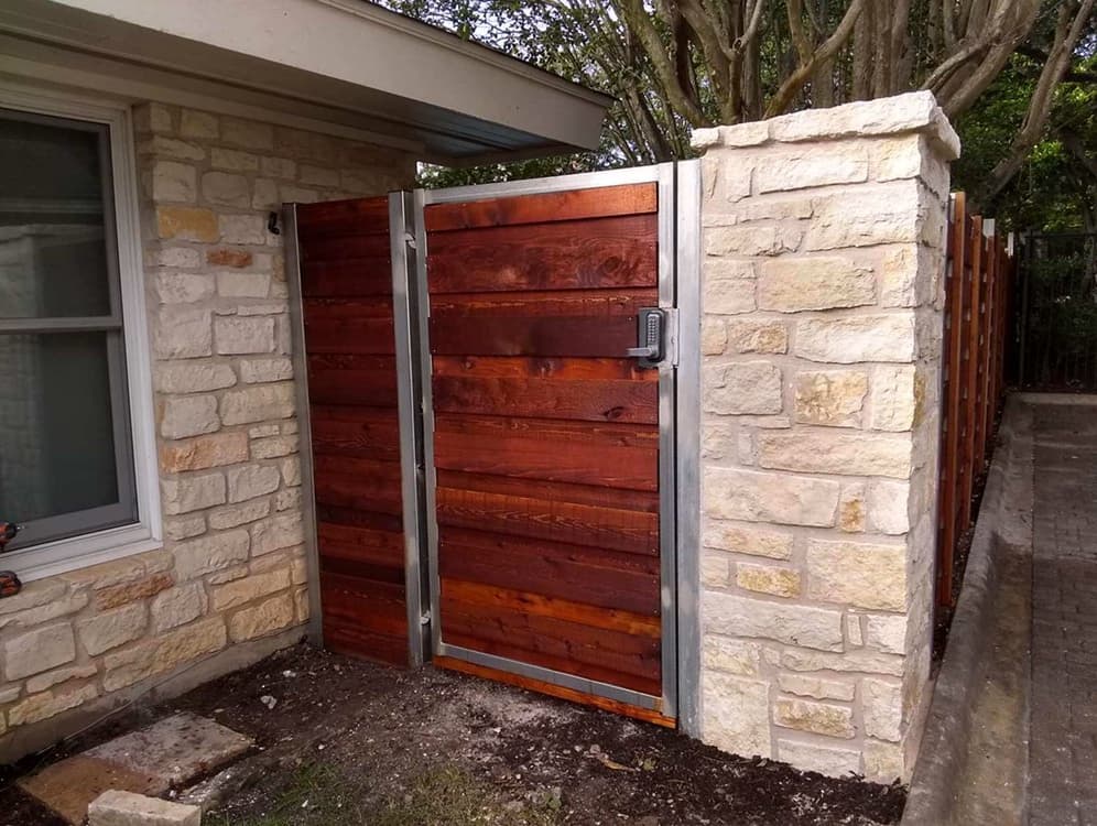 Metal-enforced wooden gate with stone posts